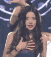 a woman with long hair is making a funny face with her hands .