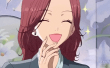 a woman with red hair and a ring on her finger smiles