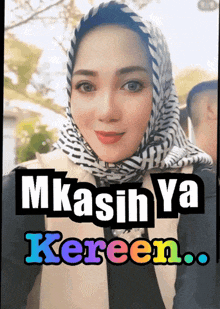 a woman wearing a scarf with the words mkasih ya kereen written on it