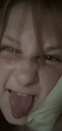 a close up of a person making a funny face with their tongue out