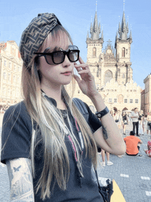 a woman wearing sunglasses and a fendi headband stands in front of a castle