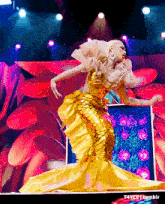 a woman in a yellow dress is dancing on a stage