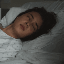 a woman in a hospital gown is sleeping in a hospital bed