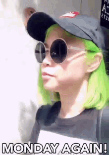 a woman with green hair wearing sunglasses and a hat says monday again ..