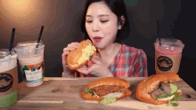 a woman eating a sandwich next to a cup that says colombia on it