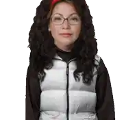 a woman wearing glasses and a white vest has a red headband