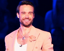 a man in a pink suit has a tattoo on his chest that says ' i love you '