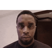 a man with a beard is making a funny face and looking at the camera .