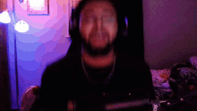 a man wearing headphones stands in front of a microphone which says 80 on it