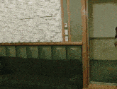 a woman is standing in a room with a couch and a wall that has a pattern of squares on it