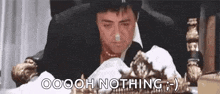 a man in a suit is sitting in a chair with a crown on his head and the words `` oooh nothing '' .