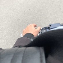 a person is riding a scooter and their hand is on the handlebars