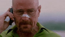 a man with a bandage on his nose talking on a cell phone