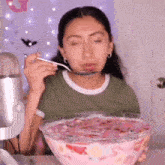a woman is eating a large bowl of ice cream with a spoon .