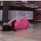 a woman in a pink dress is laying on the floor in front of a menu