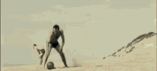 a shirtless man is playing soccer on the beach .