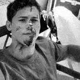 a black and white photo of a man with mud on his face and neck
