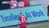 a soccer player with the number 21 on his jersey kicks the ball