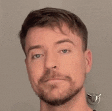 a close up of a man 's face with a beard .