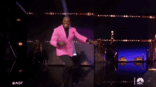 a man in a pink jacket is standing on a stage .