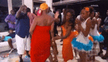 a group of people are dancing at a party in a room .