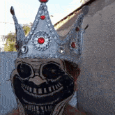 a person wearing a mask with a crown on top of it