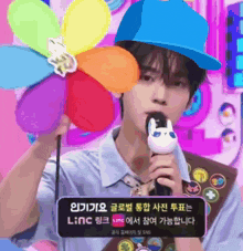 a man wearing a blue hat is holding a microphone and a flower pinwheel