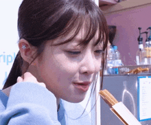 a girl with a star in her ear is eating a sandwich