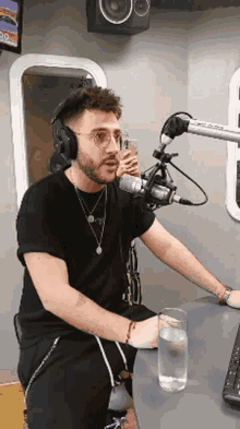 a man wearing headphones sits in front of a microphone