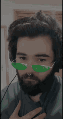 a man with a beard wearing green sunglasses and headphones