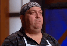 a man wearing a bandana on his head looks down