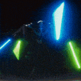 a robot is holding a pair of lightsabers in the dark .