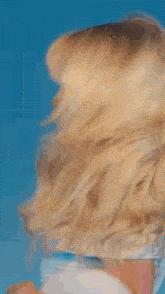 a close up of a woman 's face with her hair blowing in the wind
