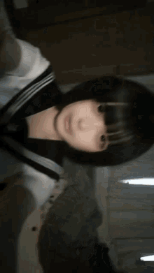 a girl with short black hair is taking a picture of herself