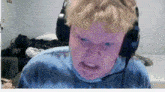 a young boy wearing headphones making a funny face .