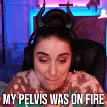 a woman wearing horns and headphones is sitting in a chair and says `` my pelvis was on fire '' .