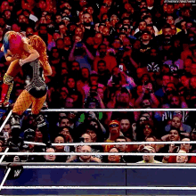 a woman in a wrestling ring with a crowd of people watching .