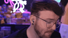 a man with a beard and glasses wearing earrings