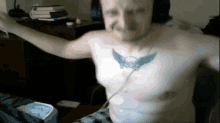 a man with a tattoo on his chest is wearing headphones