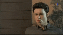 a man in a black shirt is making a funny face .