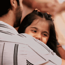 a man holding a little girl in his arms