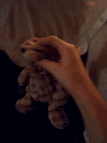 a stuffed animal is laying under a blanket
