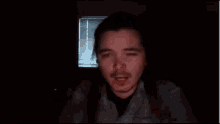 a man with a beard is making a funny face in the dark