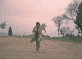 a person running on a dirt road with trees in the background