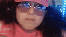 a close up of a girl wearing glasses and a hat