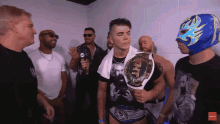 a man in a blue mask holds a tnt championship belt