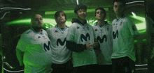 a group of men are posing for a picture and one of their shirts says mm