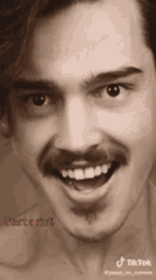 a shirtless man with a mustache is smiling with his mouth open .