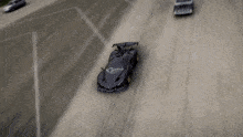 a black car and a yellow car are driving down a road