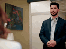 a man in a suit stands in front of a woman